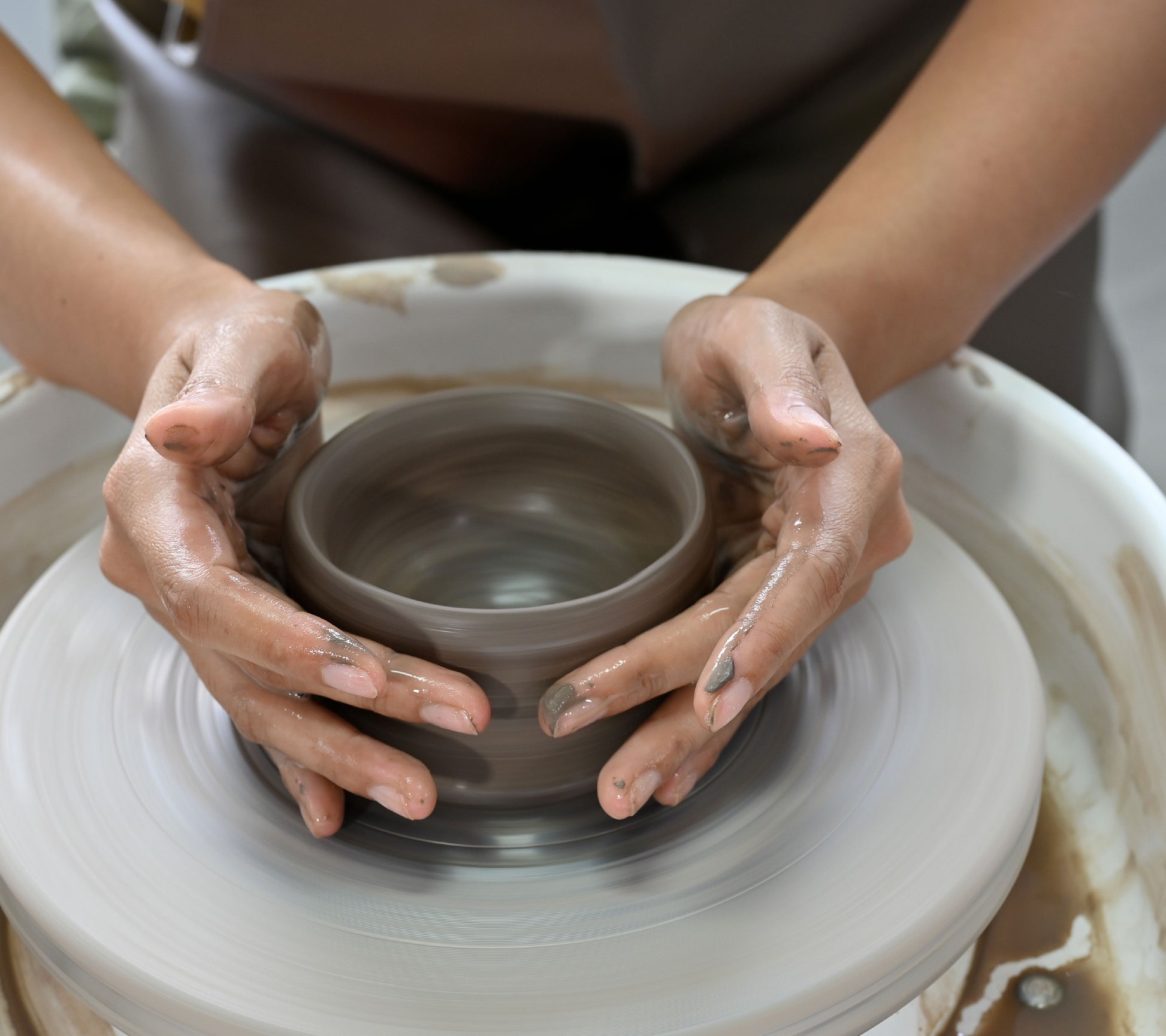 Pottery wheel, person practicing throwing clay on a pottery wheel 